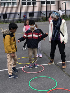 enfant les yeux bandés avançant de cerceau en cerceau